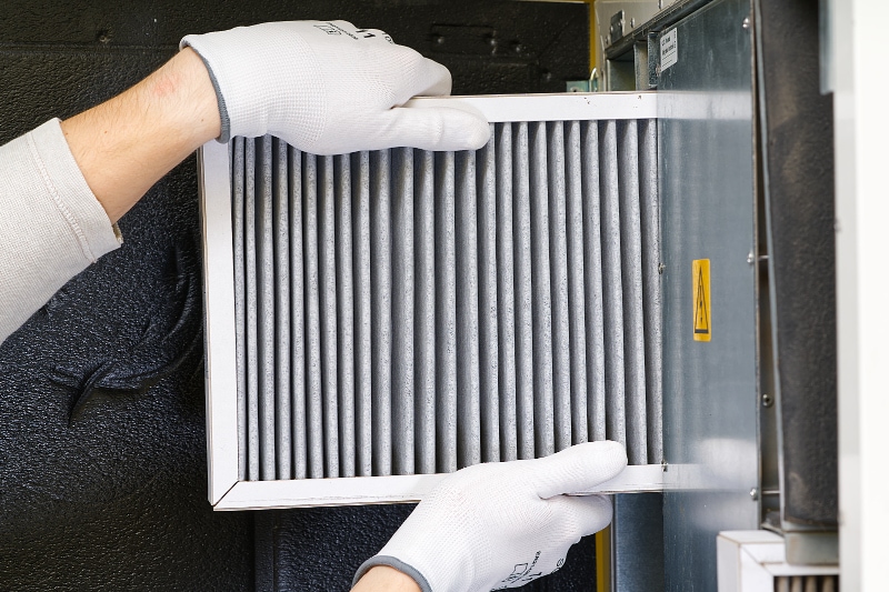 4 Reasons to Replace Your Home’s Air Filter - hvac filter replacing. Replacing the filter in the central ventilation system, furnace. Replacing Dirty Air filter for home central air conditioning system. Change filter in rotary heat exchanger recuperator.
